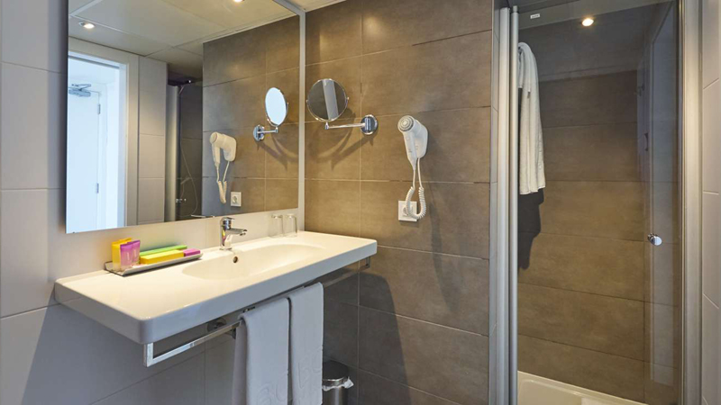 Badrum med dusch och toalettartiklar p p det 4-stjrniga hotellet BQ Apolo i Can Pastilla p n Mallorca.