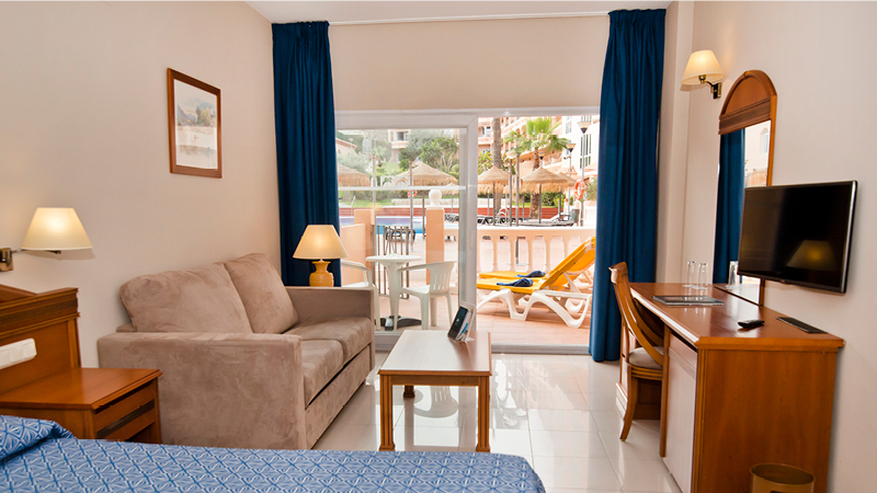 Dubbelrum med vardagsrum och terrass mot poolen på hotell Bahia Tropical i Almunecar, Andalusien.